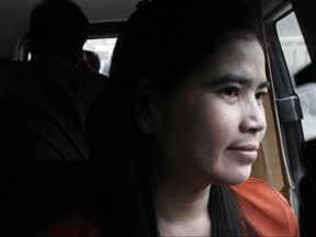 FILE - In this file photo dated Monday, Feb. 27, 2017, detained Boeng Kak lake land activist Tep Vanny sits in a van as she arrives at the Supreme Court, in Phnom Penh, Cambodia. Vanny led protests against evictions from the capital's Boeng Kak lake shore community, where the government granted a land concession to a Cambodian tycoon and a Chinese company to develop a luxury residential and commercial community, but King Norodom Sihamoni has pardoned Vanny Monday Aug. 20, 2018, just after the second anniversary of Tep Vanny's imprisonment on a charge of aggravated intentional violence.