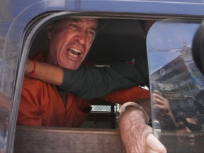 Australian filmmaker James Ricketson speaks from a prisoner van outside Phnom Penh Municipal Court, in Phnom Penh, Cambodia, Friday, Aug. 31, 2018. The 69-year-old Australian is at the court to hear his verdict Friday on a charge of violating national security that carries up to 10 years in prison.