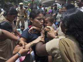 Indian police detain an activist, carrying a child, during a protest against the arrest of revolutionary writer Varavara Rao and other activists, in Hyderabad, India, Wednesday, Aug. 29, 2018. Indian police have broken up a protest and detained around two dozen people opposing the arrests this week of five prominent rights activists for suspected links to Maoist rebels in various parts of the country. Police forcibly put the protesters into their buses before driving them away on Wednesday in Hyderabad, the capital of Andhra Pradesh and Telangana states.