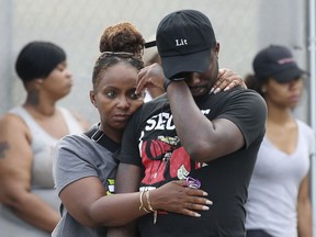 In this Sunday, Aug. 5, 2018 photo, a man wipes his eyes outside the Stroger Hospital in Chicago, after leaving the emergency room due to overwhelming crowds of family and friends of shooting victims. Police Superintendent Eddie Johnson plans to discuss the weekend violence during a Monday news conference.