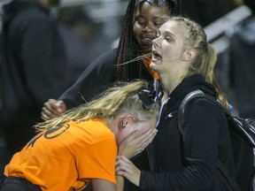 Emilie Cornelius, 14, center is comforted during the Freeport-Auburn season-opening high school football game on Friday, Aug. 24, 2018, that came to an abrupt end when gunfire rang out and spectators fled, in Rockford, Ill.