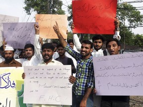 Pakistani students shout slogans to condemn a cartoon contest planned by Geert Wilders, a Dutch parliamentarian, in Lahore, Pakistan, Tuesday, Aug. 28, 2018. Pakistan's senate passed a resolution condemning an anti-Islam cartoon contest planned by the far-right Dutch lawmaker, in one of the first actions taken by the assembly since last month's elections. Placard at right reads, "Boycott Dutch products, close down their embassy."