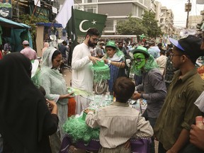 People buy national flags, badges and related merchandise to celebrate the 71st Independence Day, in Karachi, Pakistan, Monday, Aug. 13, 2018. Pakistanis will celebrate on Aug. 14, to commemorate its independence in 1947 from British colonial rule.