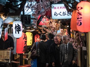 Visitors walk along Tokyo's Omoide Yokocho, a narrow lane of mainly yakitori grills and food stalls, famous amongst residents and tourists alike for its casual dining.
