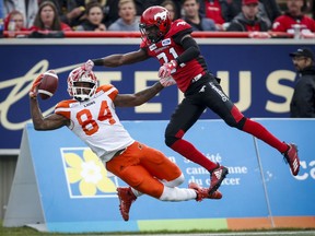 BC Lions' Emmanuel Arceneaux, left, can't hang onto the ball as Calgary Stampeders' Tre Roberson, covers him during first quarter CFL football action in Calgary, Saturday, Aug. 4, 2018.THE CANADIAN PRESS/Jeff McIntosh