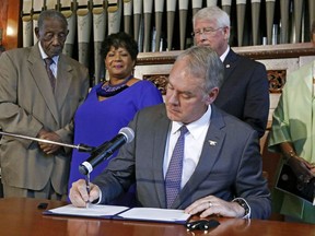 U.S. Interior Secretary Ryan Zinke signs a proclamation designating the former home of the late civil right activist Medgar Evers and his wife Myrlie Evers, into the African American Civil Rights Network, Friday, Aug. 3, 2018, at Tougaloo College in Jackson, Miss. Attending the ceremony were, from left, Charles Evers, the brother of Evers, Reena Evers-Everett, daughter of the couple, U.S. Sen. Roger Wicker, R-Miss., and Beverly Wade Hogan, president of the college.