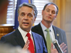 CORRECTS SPELLING OF LAST NAME TO COLYER INSTEAD OF COYLER - Kansas Gov. Jeff Colyer, left, alongside Lt. Gov. Tracey Mann, addresses the media at the Kansas Statehouse in Topeka, Kan., Wednesday, Aug. 8, 2018, a day after his primary race against Kansas Secretary of State Kris Kobach.