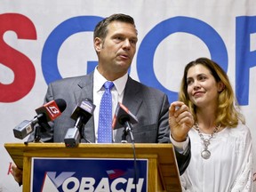 Kansas Secretary of State Kris Kobach, surrounded by his family, addresses the crowd during a joint press conference with Gov. Jeff Colyer to thank their supporters and kick off Kobach's Fall campaign at the Kansas Republican Party headquarters on Thursday, Aug. 16, 2018, in Topeka, Kan.