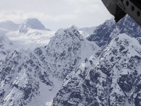 FILE - This April 24, 2016, file photo taken above the Kahiltna Glacier near Denali, shows peaks in the Alaska Range, as seen through the open cargo bay doors of a Chinook helicopter. Searchers said Monday, Aug. 6, 2018, that they found four people dead in a sightseeing airplane carrying Polish tourists in Alaska's Denali National Park a day and a half after thick clouds hampered the response to a distress call. Another person is missing and presumed dead after the crash Saturday evening.