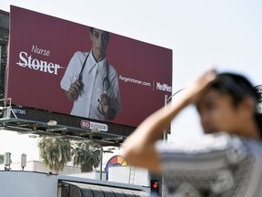 This May 9, 2018 photo shows a billboard for MedMen, a marijuana dispensary, at an intersection in Los Angeles. MedMen recently rolled out an ad campaign that featured photos of 17 people including a white-haired grandmother, a schoolteacher, a business executive, a former pro football player and a nurse, being splashed across billboards, buses and the web.
