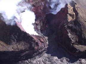 In this Aug. 11, 2018 aerial photo provided by the United States Geological Survey shows diminished volcanic activity on Kilauea's lower East Rift Zone. Slowing activity at Hawaii's Kilauea volcano is prompting scientists to downgrade their alert level for the mountain. The U.S. Geological Survey said Friday, Aug. 17, it issued a "watch" for Kilauea's ground hazards; that's down from a "warning." Geologists say lava mostly stopped flowing on Aug. 6. (USGS via AP)