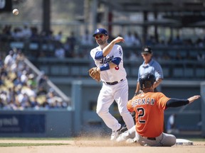 Los Angeles Dodgers second baseman Brian Dozier, top, turns a double play over Houston Astros' Alex Bregman (2) during the eighth inning of a baseball game in Los Angeles, Sunday, Aug. 5, 2018. Marwin Gonzalez was out at first.