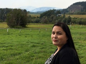 Miranda Louie, spokeswoman for the Nadleh Whut‚Äôen First Nation, stands on the band‚Äôs territory as smoke from the Shovel Lake wildfire rising from the mountains in the far distance in Fort Fraser, B.C., on Thursday, Aug. 23, 2018.