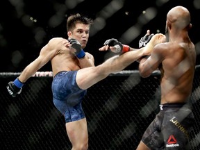 Henry Cejudo, left, kicks Demetrious Johnson during their UFC flyweight title mixed martial arts bout at UFC 227 in Los Angeles, Saturday, Aug. 4, 2018.