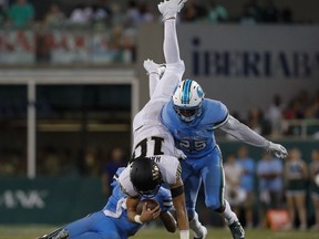 Tulane's Roderic Teamer Jr., left, and Will Harper, right, tackle Wake Forest quarterback, Sam Hartman (10) during the first half of an NCAA college football game in New Orleans on Thursday, Aug. 30, 2018.