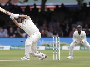 England's Chris Woakes plays a shot off the bowling of India's Ishant Sharma during the fourth day of the second test match between England and India at Lord's cricket ground in London, Sunday, Aug. 12, 2018.