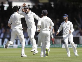 India's captain Virat Kohli celebrates as India's Ishant Sharma, left, takes the wicket of England's Alastair Cook during the third day of the second test match between England and India at Lord's cricket ground in London, Saturday, Aug. 11, 2018.