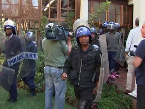 In this image made from video, police arrive at a press conference by opposition leader Chamisa in Harare, Friday, Aug. 3, 2018. Zimbabwean police have broken up a press conference by opposition leader Chamisa, who rejects election results. (AP Photo)