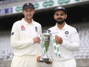 England captain Joe Root, left, and India captain Virat Kohli hold the Test match trophy during a media event at Edgbaston, Birmingham, England, Tuesday July 31, 2018.