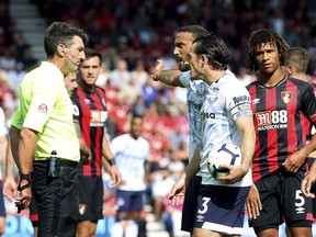 Everton's Richarlison second right background, reacts after being sent off by referee Lee Probert, left, during the English Premier League soccer match Between Bournemouth and Everton,  at the Vitality Stadium, in Bournemouth, England, Saturday, Aug. 25, 2018.