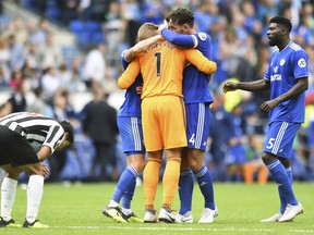 Cardiff City players congratulate goalkeeper Neil Etheridge after saving a penalty from Newcastle United's Kenedy, during their English Premier League soccer match at the Cardiff City Stadium, Wales, Saturday Aug. 18, 2018.