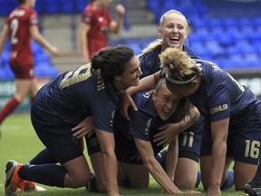Manchester United Women's Lizzie Arnot, centre down,  celebrates after scoring her sides first goal during a domestic cup game at Prenton Park in Liverpool, England, Sunday Aug. 19, 2018. In its first competitive game in 13 years, United's women's side beat Liverpool 1-0 in a domestic cup game that marked a new era on Sunday.