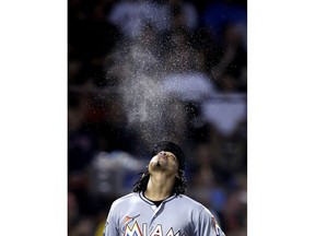 Miami Marlins pitcher Jose Urena spouts liquid from his mouth as he heads to the mound to face the Boston Red Sox during the sixth inning of a baseball game against the Boston Red Sox at Fenway Park in Boston, Tuesday, Aug. 28, 2018. Urena allowed four runs on six hits during his six inning outing.