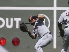 Cleveland Indians left fielder Melky Cabrera loses a fly ball in the sun for a single by Boston Red Sox's Mitch Moreland in the first inning of a baseball game at Fenway Park, Thursday, Aug. 23, 2018, in Boston.