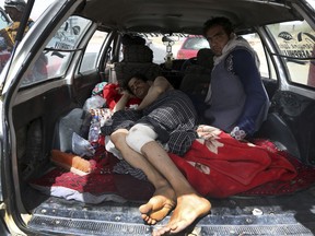 FILE - In this Monday, Aug. 13, 2018 file photo, An injured man is transported on the Ghazni highway, in Maidan Shar, west of Kabul, Afghanistan. Talks next month in Moscow to discuss a peaceful end to 17-years of war in Afghanistan that includes a place at the table for the Taliban has ruffled feathers in Washington and Kabul, who are refusing to attend, and resurrected Cold War memories.