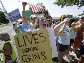 Chloe Carr, 18, of Natick, Mass., front, holds a placard and chants slogans during the final mile of a 50-mile march, Sunday, Aug. 26, 2018, in Springfield, Mass. The march, held to call for gun law reforms, began Thursday, Aug. 23, 2018, in Worcester, Mass., and ended Sunday, in Springfield, with a rally near the headquarters of gun manufacturer Smith & Wesson.