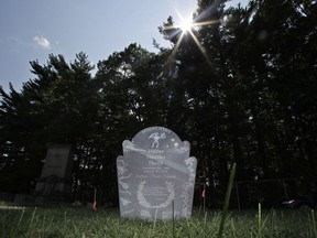 The sun peers over the tree line at the gravesite of Walter Skold at the Pine Grove Cemetery in Brunswick, Maine., Monday, Aug. 27, 2018. Skold, who was founder of the Dead Poets Society of America, died of a heart attack at the age of 57 in January 2018, little more than a month after enlisting the son of novelist John Updike to carve a unique grave marker.