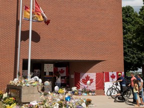 Mourners attend a memorial for Fredericton police constables Sara Burns and Robb Costello at the police station in Fredericton on Thursday, Aug. 16, 2018.