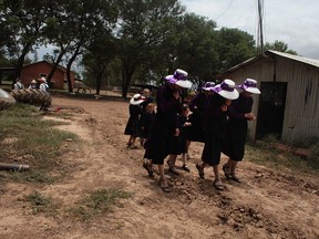 Manitoba, Bolivia 2009. Mennonite sisters, all dressed in the same handmade dresses and traditional Mexican hats, visit neighbouring families on a Sunday afternoon after church, when families are allowed to visit one another to chat.