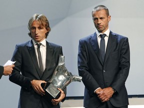 Luka Modric, left, holds his UEFA Men's Player of the Year trophy as he stands next to UEFA President Aleksander Ceferin during the UEFA Champions League draw at the Grimaldi Forum, in Monaco, Thursday, Aug. 30, 2018.