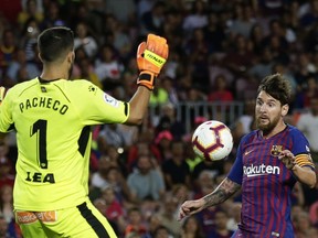 FC Barcelona's Lionel Messi, right, vies for the ball against Alaves goalkeeper Pacheco during a Spanish La Liga soccer match at Camp Nou stadium in Barcelona, Spain, Saturday, Aug. 18, 2018.