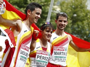 Spain's gold medalist Alvaro Martin, right, female gold medalist Maria Perez, center, and silver medalist Diego Garcia Carrera, left, celebrate after their 20-kilometer race walk at the European Athletics Championships in Berlin, Germany, Saturday, Aug. 11, 2018.