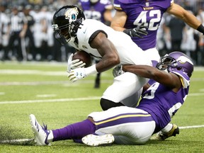 Jacksonville Jaguars wide receiver Marqise Lee is tackled by Minnesota Vikings defensive back Xavier Rhodes, right, during the first half of an NFL preseason football game, Saturday, Aug. 18, 2018, in Minneapolis.