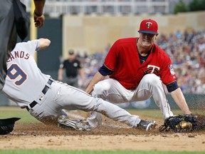 Minnesota Twins pitcher Kyle Gibson, right, covers the plate but Detroit Tigers' Nicholas Castellanos (9) beats the tag to score on a wild pitch by Gibson in the fourth inning of a baseball game Friday, Aug. 17, 2018, in Minneapolis.