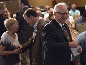 Candidates for Minnesota governor Tim Walz, democrat, right, and Jeff Johnson, republican, left,  mingle with the crowd before their first debate Friday, Aug. 17, 2018, at Grand View Lodge, Nisswa, Minn.