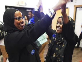 Degha Shabbeleh, left, and Maymuna Sahal, supporters of Congressional District 5 candidate Ilhan Omar, celebrate incoming results at Safari Restaurant in south Minneapolis, Tuesday, Aug. 14, 2018. Somali-American legislator Ilhan Omar made history Tuesday, Aug. 14, 2018, by winning the Democratic congressional primary in a Minneapolis-area district so reliably liberal that her victory is likely her ticket to Congress.