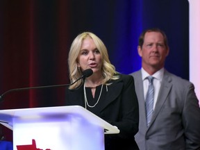 In a Friday, June 1, 2018 photo, Minnesota state Sen. Karin Housley, R-St. Mary's Point, speaks to delegates at the Republican Party of Minnesota convention as her husband, NHL Hall of Famer Phil Housley, looks on in the Duluth, Minn., convention center.