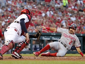 Washington Nationals' Adam Eaton (2) scores past St. Louis Cardinals catcher Yadier Molina during the fourth inning of a baseball game Thursday, Aug. 16, 2018, in St. Louis.