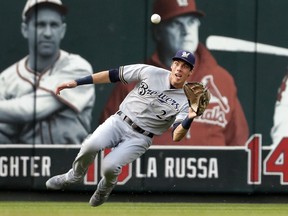 Milwaukee Brewers left fielder Christian Yelich dives to catch a fly ball by St. Louis Cardinals' Paul DeJong for an out during the second inning of a baseball game Saturday, Aug. 18, 2018, in St. Louis.