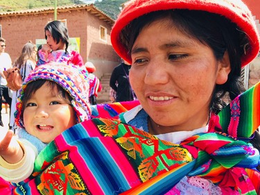 A mother and child greet visitors at the Ccaccaccollo Women's Weaving Co-op.