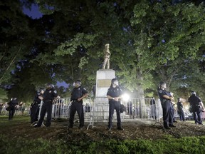 n this Tuesday, Aug. 22, 2017 file photo, police surround the "Silent Sam" Confederate monument during a protest to remove the statue at the University of North Carolina in Chapel Hill, N.C. In North Carolina, officials are trying to determine whether this and other Confederate memorials have become public safety hazards _ a determination that opponents believe could fulfill an exception to a 2015 law preventing their permanent removal.