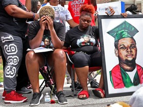 Trinetta, center left, 19, and Triniya Brown become emotional during a memorial service for their brother, Michael Brown, on Thursday, Aug. 9, 2018, in the Canfield Green apartment complex in Ferguson, Mo., where Brown was shot and killed by former Ferguson police officer Darren Wilson four years ago.