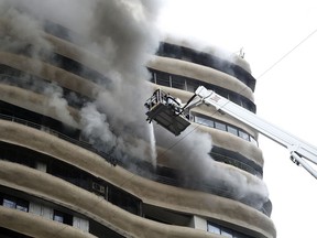 Smoke emits as fire brigade personnel try to douse a fire on the 12th floor of Crystal Tower, a residential  building in Mumbai, India, Wednesday, Aug.22, 2018. Four people were killed and 12 others were injured according to officials.