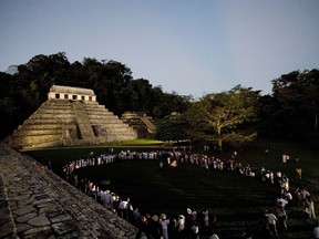 FILE - In this March 10, 2008 file photo, participants of 'Indigenous People to Heal Our Mother Earth'' hold a pre-dawn ceremony at the foot of Mayan ruins in Palenque, Mexico. Mexico's president-elect Andres Manuel Lopez Obrador wants to build a train that would run from Cancun to Palenque, but it's not the first time ambitious rail projects have been proposed: current President Enrique Pena Nieto announced in 2012 he would build a rapid train link connecting the Riviera Maya with Merida. It was cancelled due to a lack of funds.