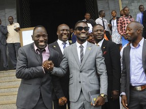 FILE - In this Tuesday, July 11, 2017 file photo, Ugandan pop star Kyagulanyi Ssentamu, better known as Bobi Wine, centre, leaves shortly after being sworn in as a member of parliament in Kampala, Uganda. On Thursday, Aug. 23, 2018 Ugandan military prosecutors withdrew weapons charges against the jailed pop star and lawmaker who opposes the longtime president.