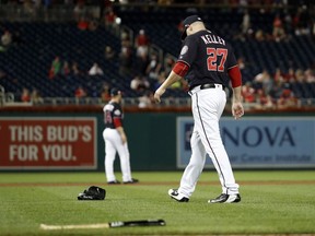 Washington Nationals relief pitcher Shawn Kelley (27) walks to pick up his glove after throwing it after giving up a two-run homer during the ninth inning of a baseball game against the New York Mets at Nationals Park, Tuesday, July 31, 2018, in Washington. The Nationals won 25-4. Kelley's outburst on the mound got him booted from the Washington Nationals. The Nationals designated Kelley for assignment on Tuesday.